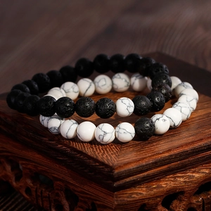 Lava stone and white turquoise beaded bracelets set on a traditional wooden stand