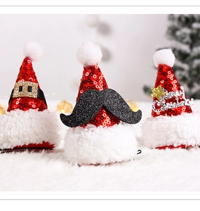Close-up of sparkling sequin Christmas hat hair clips with Santa belt and beard details