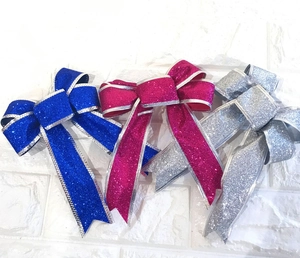 Detail of glitter Christmas bows in blue, magenta, and silver with metallic edges