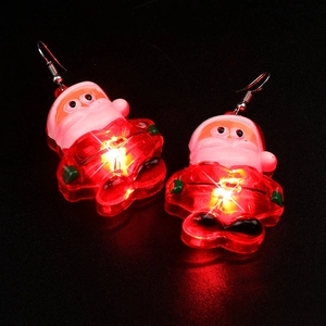 Macro shot of glowing Santa Claus LED earrings with festive red and white lights