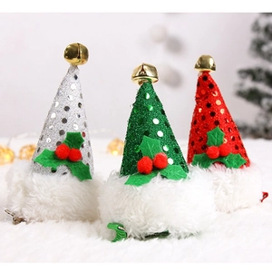 Three sequined Christmas hat hair clips with bells and holly on white fur background