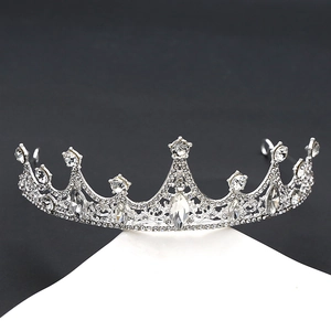 Detailed view of silver crystal tiara featuring drop-shaped rhinestones on a white stand