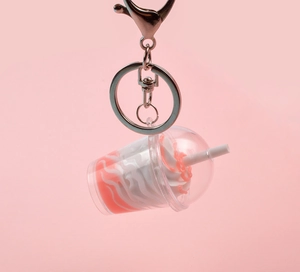 Détail d'un porte-clés miniature de sundae aux fraises avec mousqueton en métal