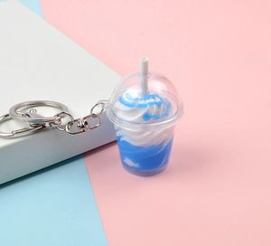 Détail d'un porte-clés créatif mini tasse de smoothie bleu avec décoration crémeuse
