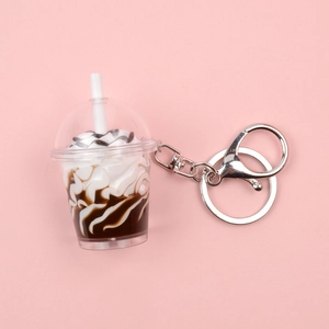 Porte-clés tasse de thé au lait miniature avec fermoir argenté sur fond rose