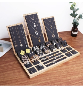 Macro view of wooden jewelry display set with gray velvet liners for necklaces and rings