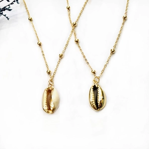 Ensemble collier pendentif coquillage bohème avec plaquage or sur fond blanc minimaliste