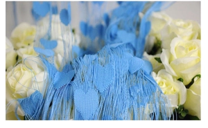 Detail of blue heart string curtain fringe with romantic floral backdrop for home decor