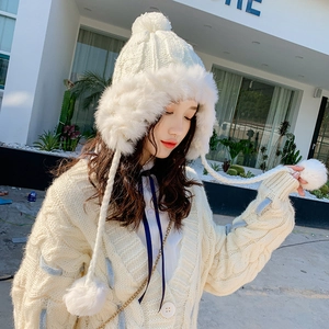 White knitted winter trapper hat for women with faux fur trim and dual pom-poms