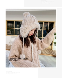 Detail of cream knit trapper hat with fluffy faux fur trim and top pom-pom detail