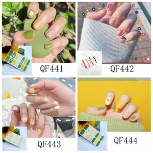 Detail view of 3D nail stickers featuring floral, polka dot, and lemon designs for manicure