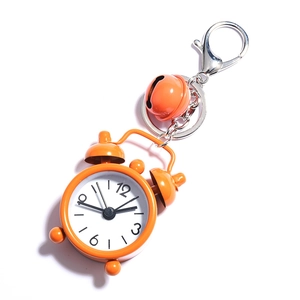 Detail of orange mini alarm clock keychain with matching bell and silver metal clasp