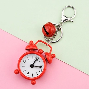 Close-up detail of a red mini alarm clock keychain with a small bell for bag charm