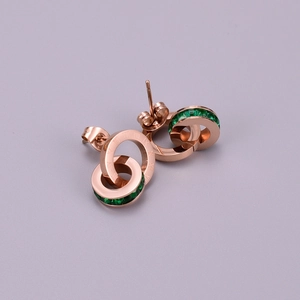 Detail of rose gold double interlocking earrings with green zircons and Roman numerals