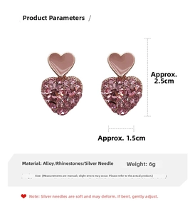 Detail view of pink heart earrings with enamel heart stud and rhinestone crystal pendant