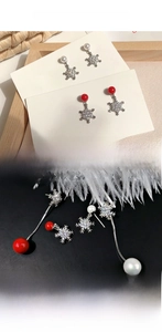 Detailed view of silver snowflake earrings with pearls and crystals on decorative display