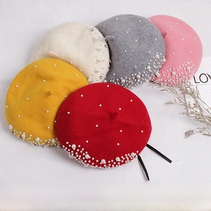 Detail view of pearl and rhinestone embellished wool berets in five elegant colors