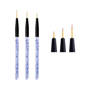 Macro detail of three professional nail art liner brushes with blue glitter acrylic handles