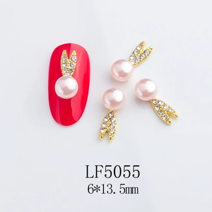 Macro view of pink pearl and rhinestone rabbit charms for DIY nail art decoration