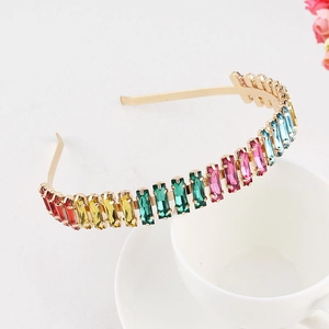 Detail of colorful crystal headband on white cup background with pink dried flowers