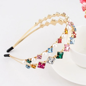 Detail of double-layer gold headband with colorful rhinestones and white pearls on white cup