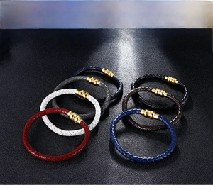 Close-up of multicolored braided leather bracelets with gold magnetic clasps for men