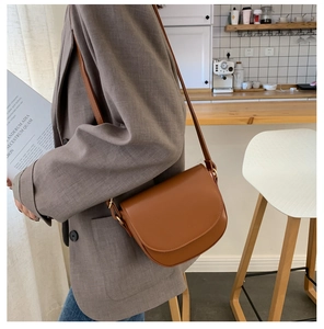Braune Satteltasche aus PU-Leder mit verstellbarem Gurt, getragen von einem Model