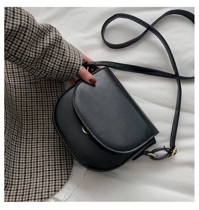 Detail einer minimalistischen schwarzen Satteltasche aus PU-Leder mit Goldbeschlägen
