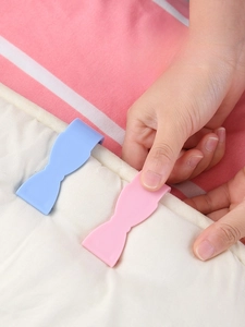 Bow-shaped needle-free duvet clips in pink and blue for secure bedding fastening