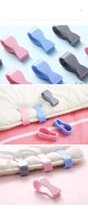 Detail view of 6-piece plastic duvet clips in pink blue and grey for bedding security
