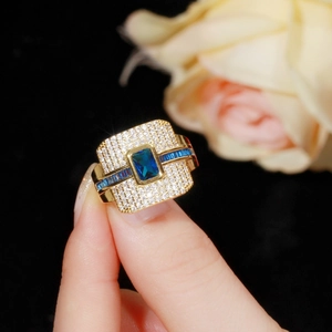Luxurious gold-plated ring with a blue rectangular gemstone and micro-pave white zircon