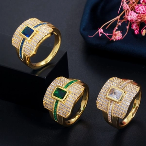 Detailed view of gold plated rings featuring rectangular gemstones and micro-pave zircons