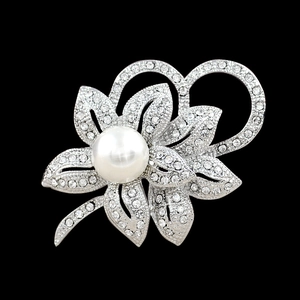 Detail of floral silver brooch with white pearl center and sparkling crystals on black back
