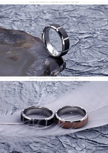 Detail of stainless steel ring with black brushed texture and walnut wood grain inlay