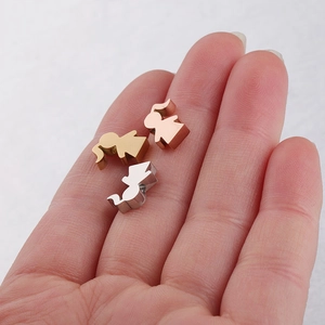 Polished stainless steel girl figure charms in gold, silver and rose gold on a palm
