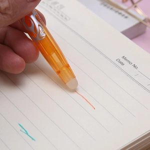 Orange 0.5mm erasable gel pen with flame design held over a notebook for school