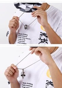 Détail du pendentif tête de mort vintage avec gravures et chaîne à perles en acier