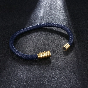 Minimalist navy blue braided leather bracelet with 18K gold magnetic clasp on black surface