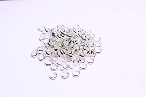 Close-up of bulk silver-plated metal beads and round spacer rings for jewelry making