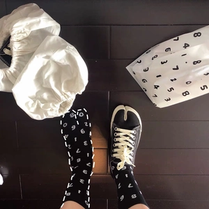 Flat lay of black Tabi split-toe canvas shoes and matching socks with white numbers