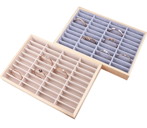 Detail view of 40-slot wooden jewelry tray with beige and grey velvet inserts