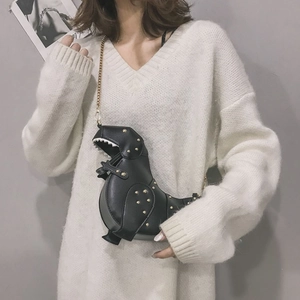 Detail of creative black dinosaur crossbody bag with gold studs and chain strap