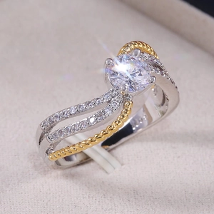 Vue latérale macro d'une bague bicolore avec zircon rond dans une sertissure à quatre griffes
