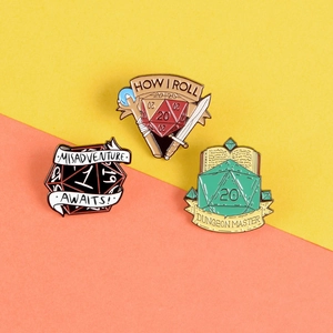 Detailed view of D20 dice enamel pins featuring swords, magic books, and RPG quotes