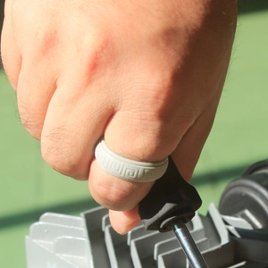 Detail shot of grey silicone ring with embossed Greek key pattern during outdoor work