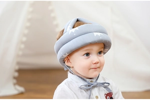 Detail view of a gray infant safety helmet with crown pattern and secure chin straps