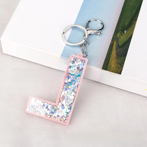 Detail of pink acrylic letter L keychain with silver iridescent sequins and lobster clasp