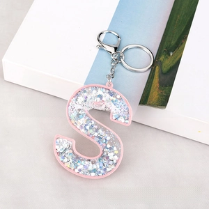 Detailed view of S-shaped pink acrylic keychain with sparkling silver glitter filling