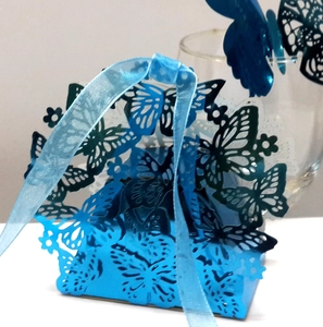 Blue laser-cut butterfly candy box with matching ribbon and elegant hollow heart detail