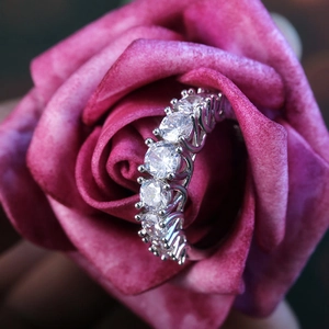 Elegant claw-set zirconia eternity ring nestled in a pink rose for wedding jewelry